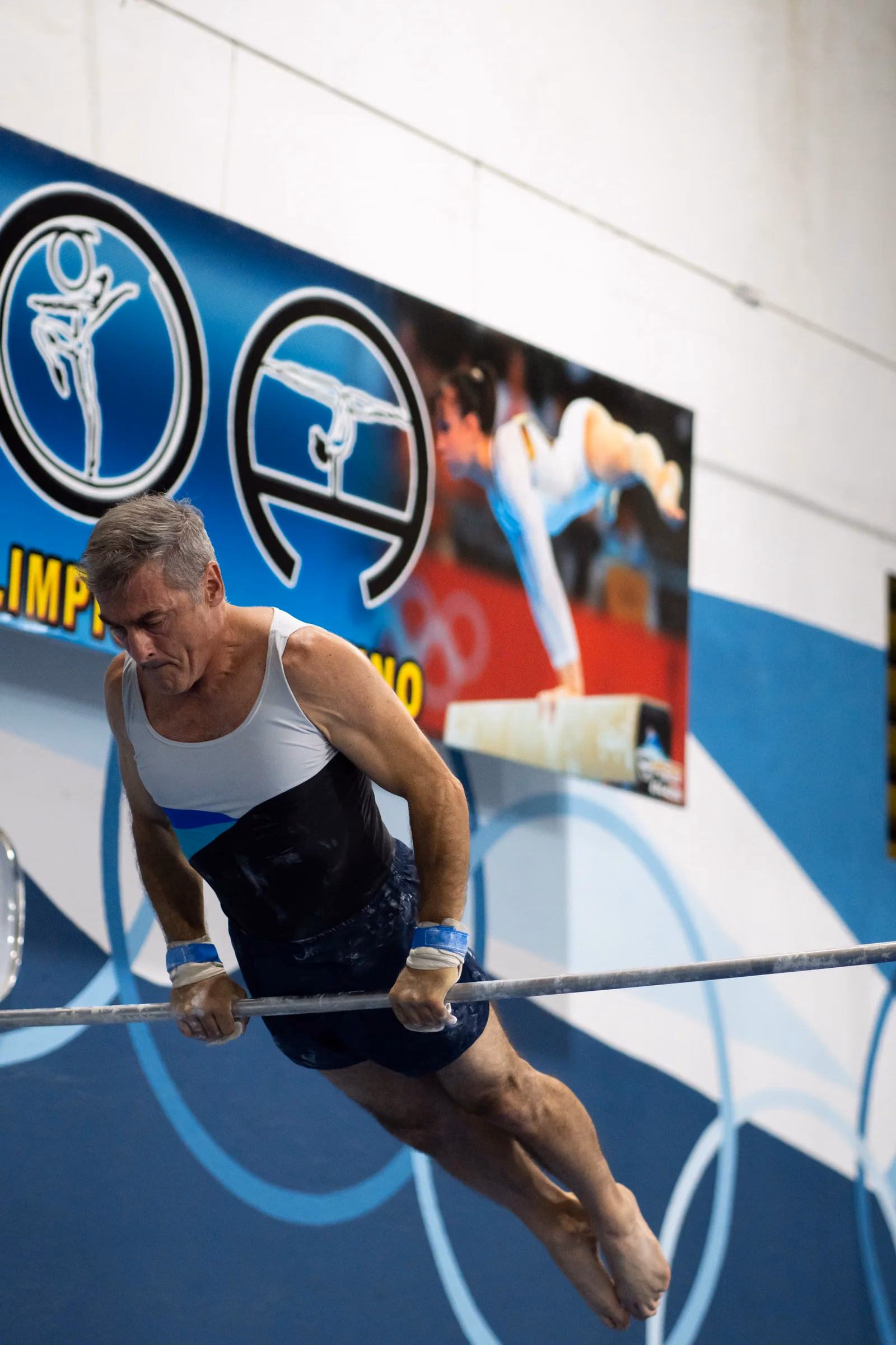 Gimnasta adulto del club en la barra fija