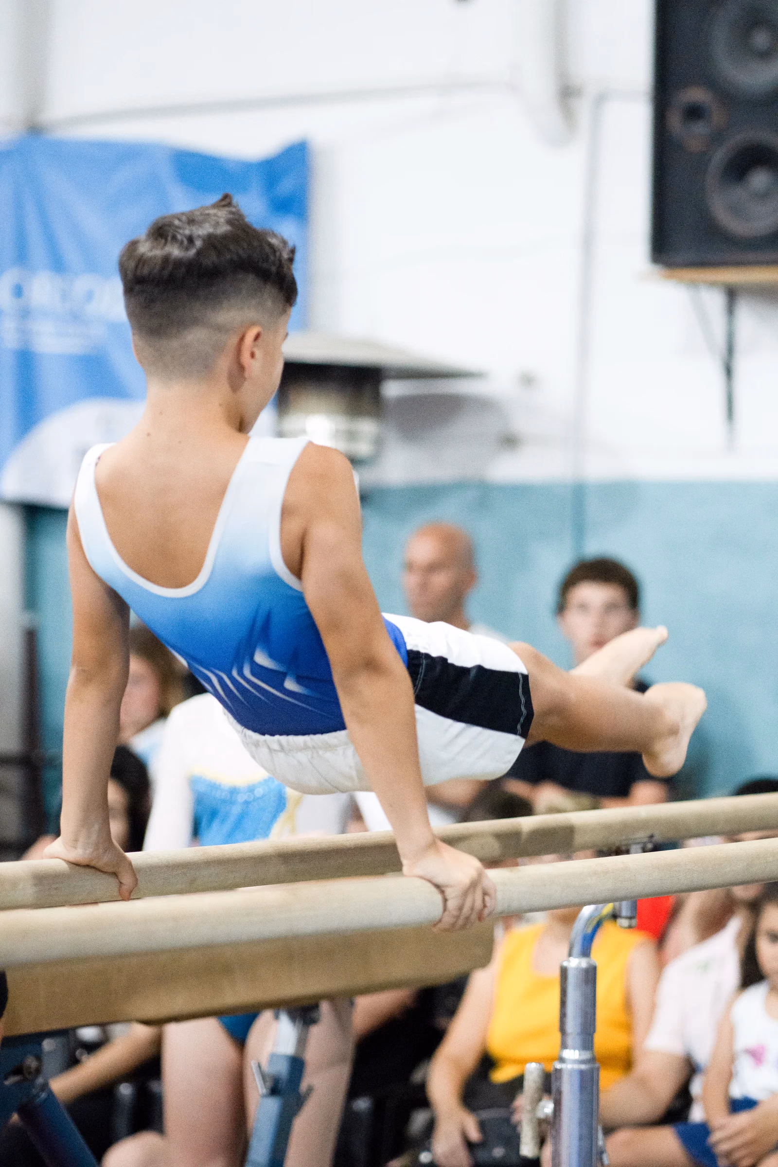 Gimnasto del club en las barras paralelas