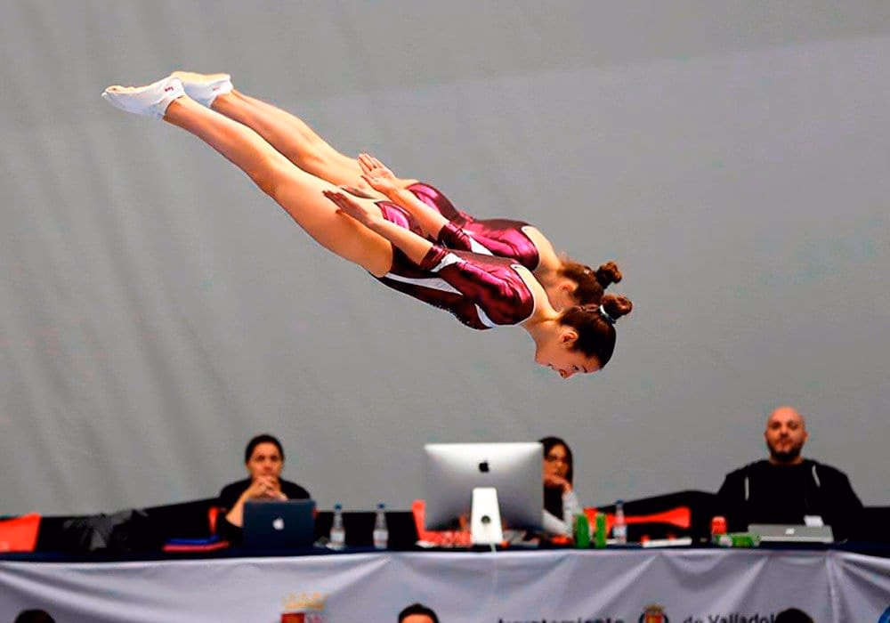Gimnasta en pleno salto sobre el trampolín